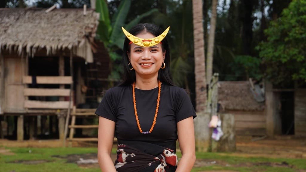 photo of an Indigenous woman in traditional dress, standing outdoors